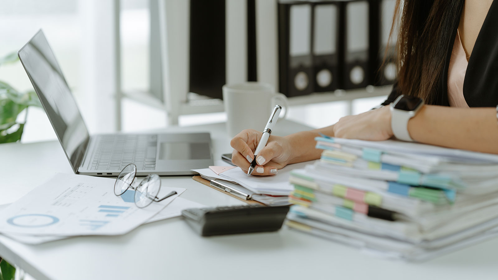 Businessman working in stacks of papers searching for unfinished paperwork information on form check stack on table and checking financial papers in busy workload